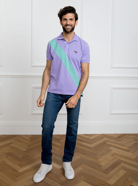 Man wearing lilac 100% cotton polo shirt with avocado green sash detail and Newmarket 875 horse logo embroidered on the front.